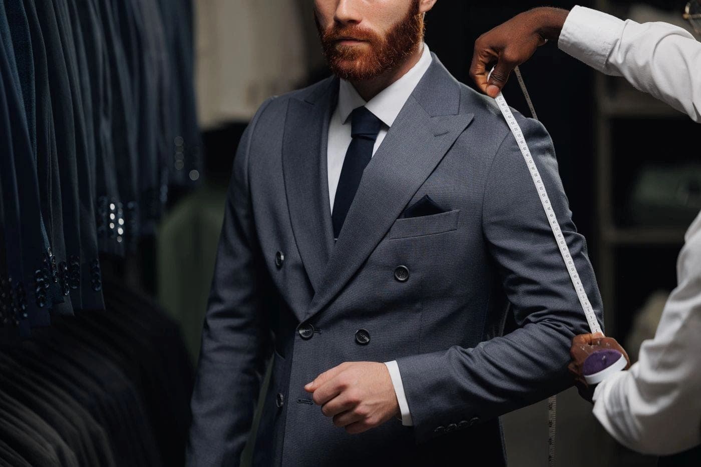 A client being measured for a custom double-breasted suit