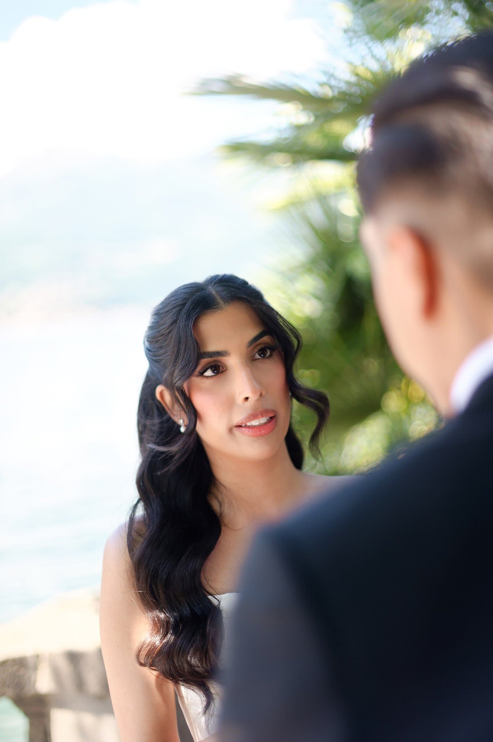 The bride looking at the groom during their first look on the villa terrace