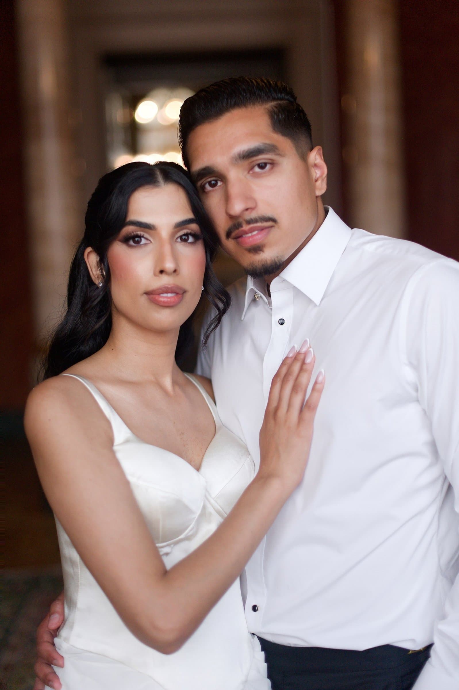 The couple in an embrace in a villa salon, she in white silk, he in a white shirt