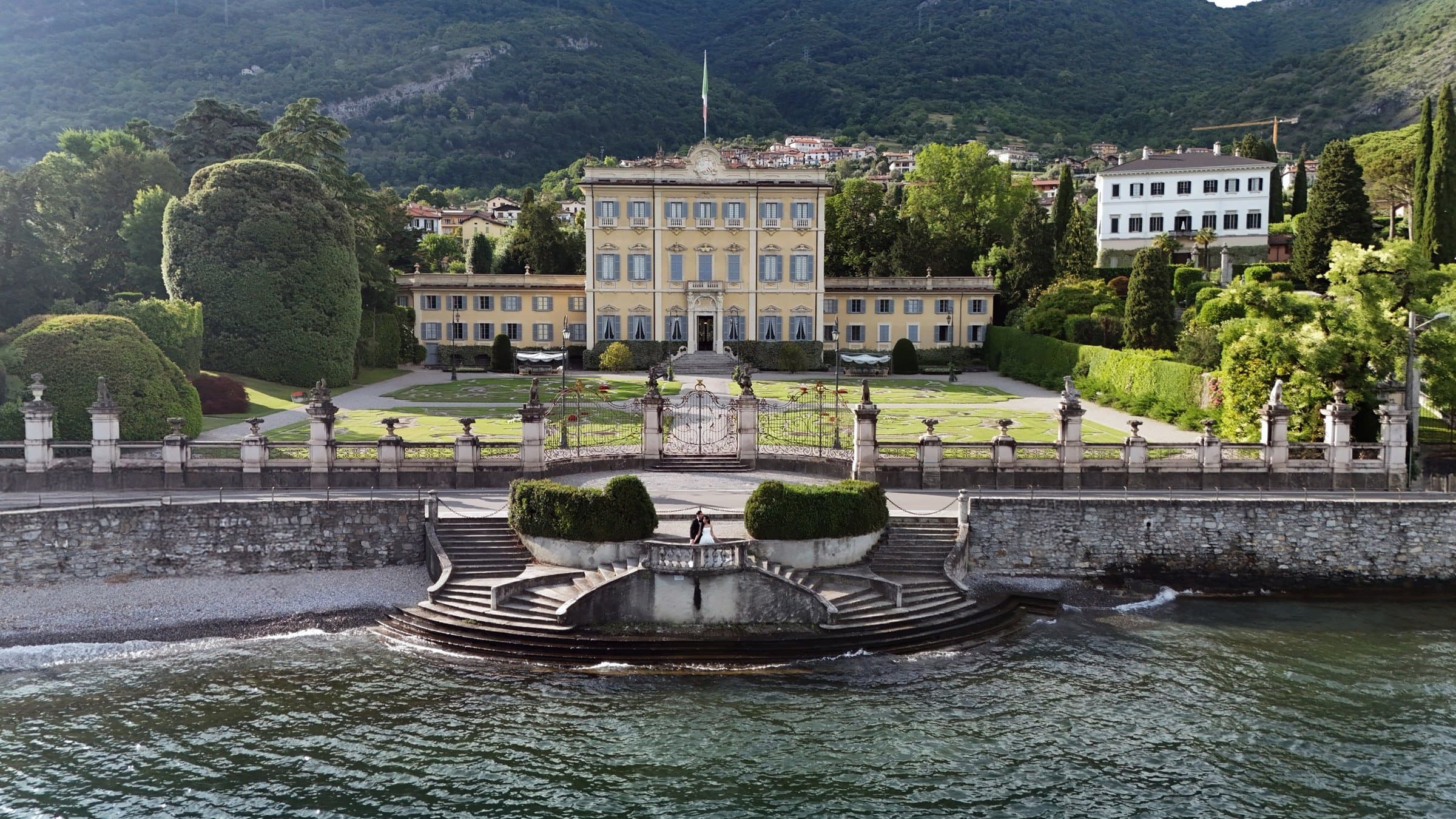 A lakeside villa and its formal gardens on Lake Como, seen from the water