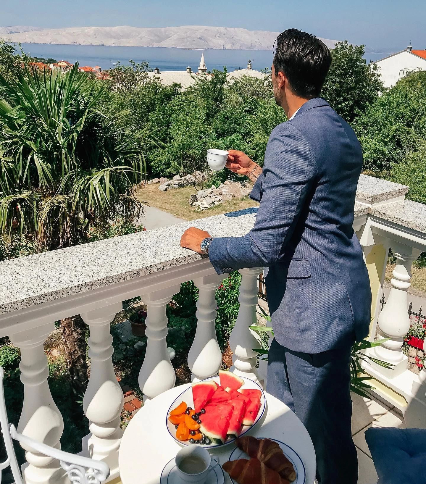 Man wearing a blue business suit on a dining terrace, tailored in Edmonton