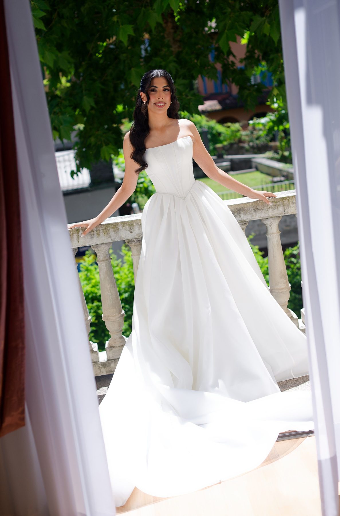 The bride stepping onto a villa balcony above the garden