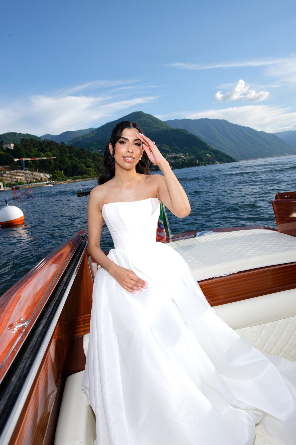 The bride on the deck of a wooden Riva crossing Lake Como