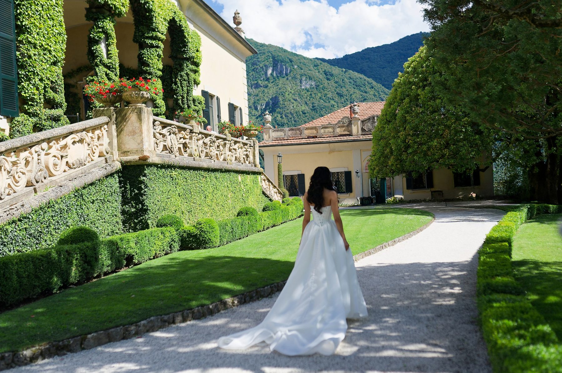 The bride walking a gravel path through the villa gardens