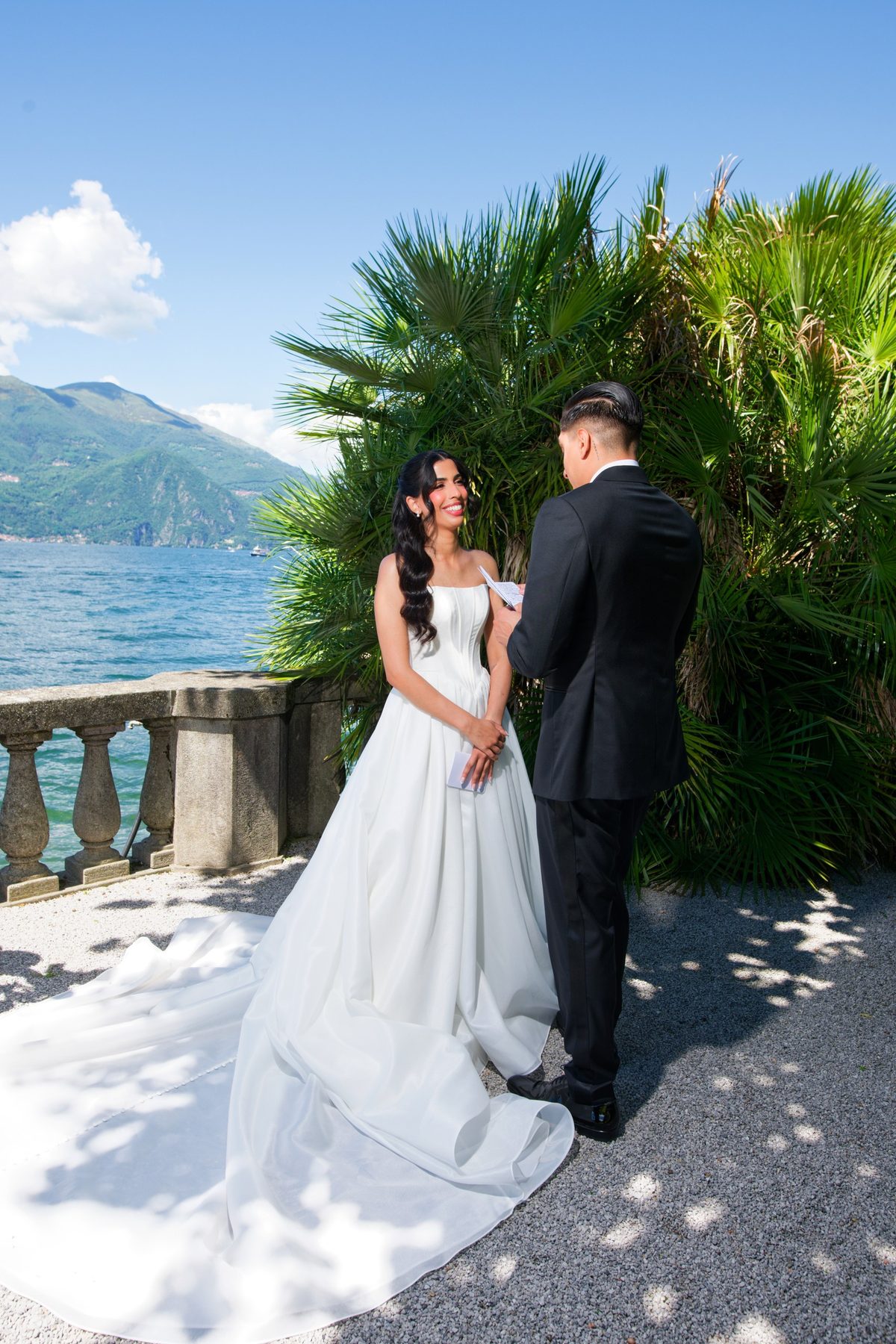 The couple embracing on the terrace with Lake Como behind them