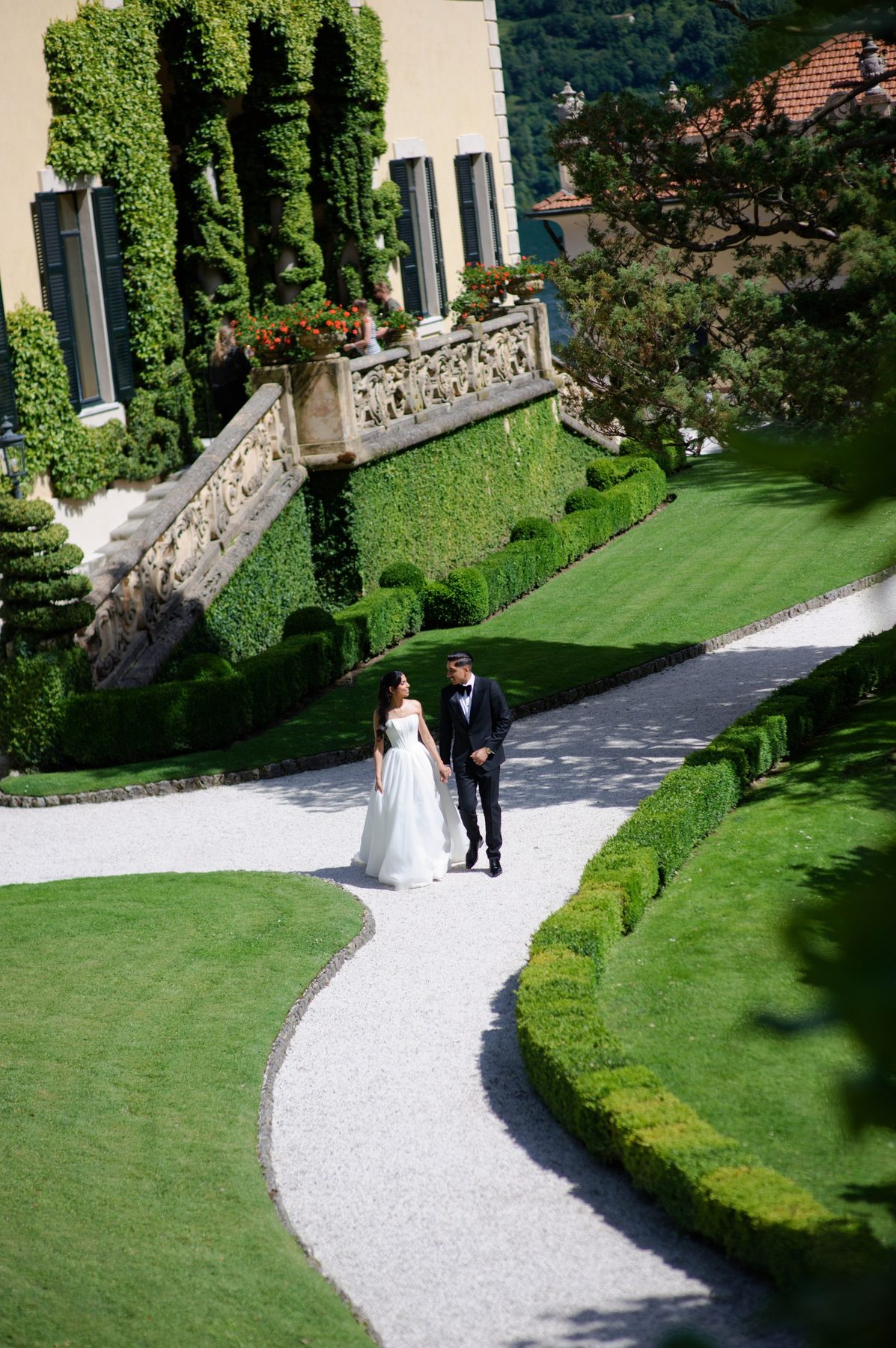 The couple on a curving path through the villa lawns