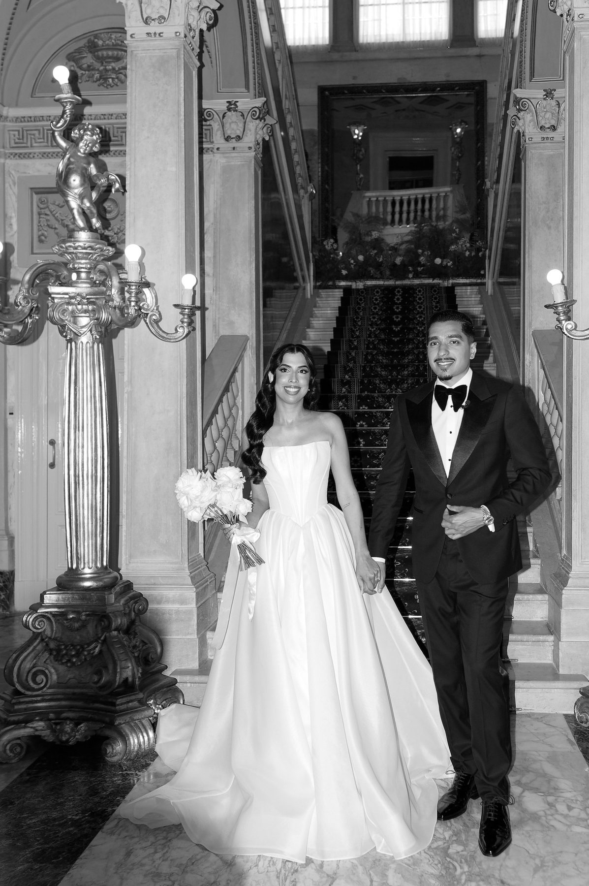 The couple on the villa staircase, the bride's train falling behind her