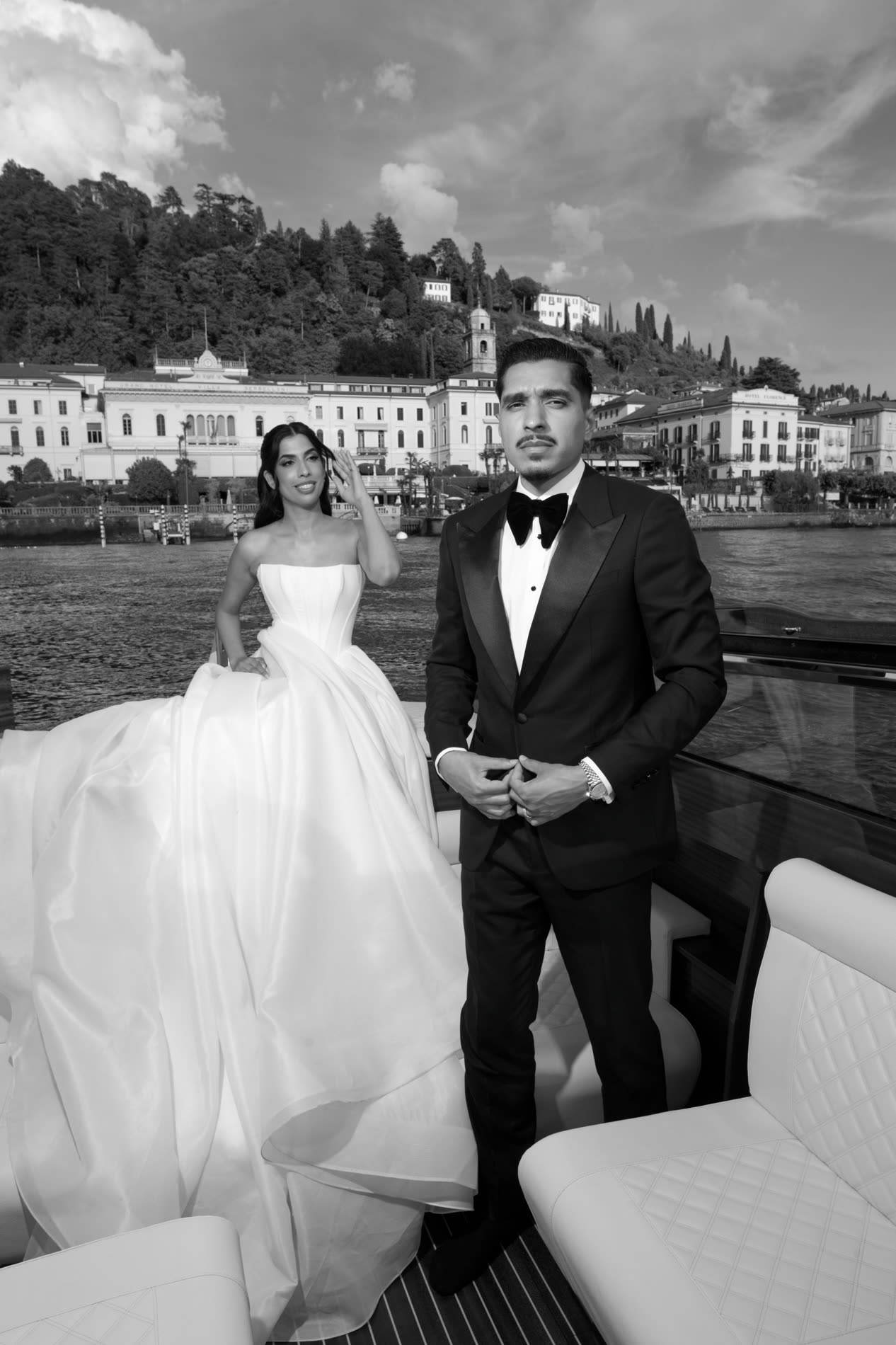 A bride and groom on a boat at Bellagio, the groom in a Conxeppt custom black tuxedo