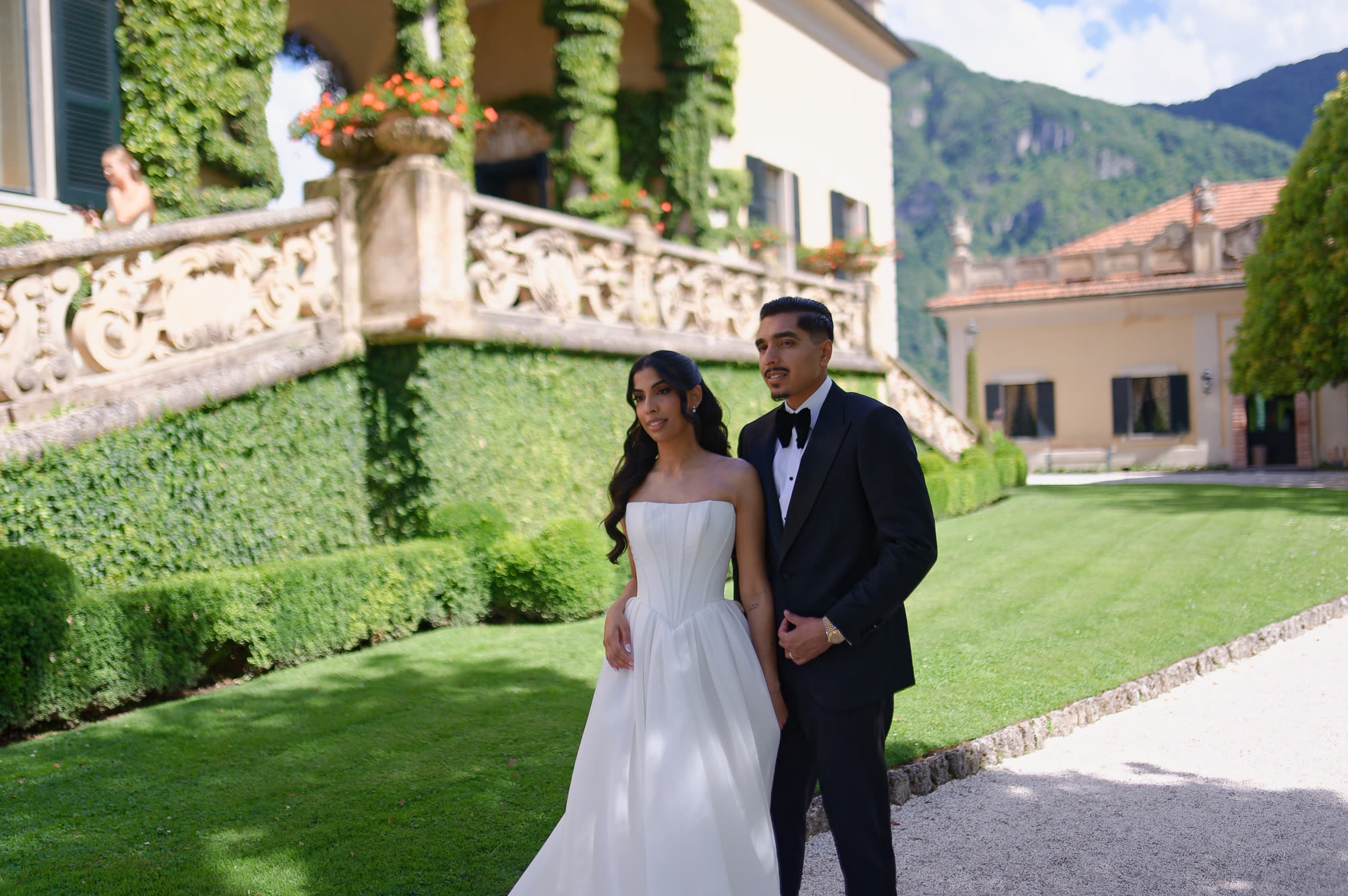 A groom in a Conxeppt custom black tuxedo on the villa lawn at Lake Como