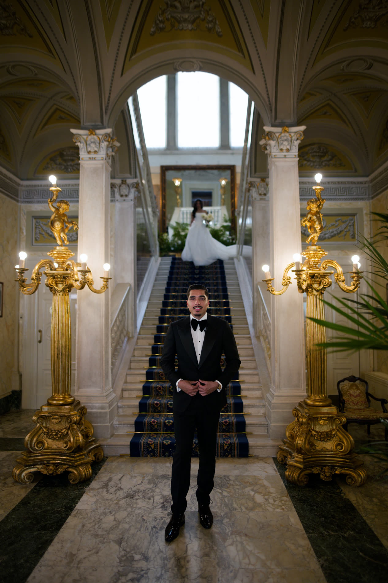 A groom in a custom tuxedo beneath the villa arch