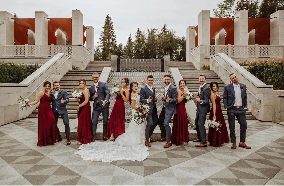 Wedding party standing on patterned stone steps, wedding suits tailored in Edmonton