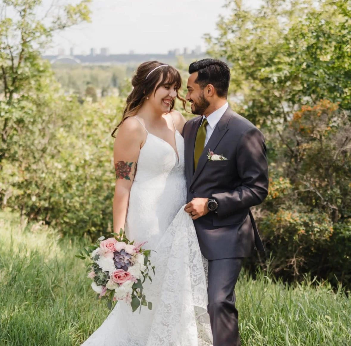 Couple kissing in a garden, the groom in a navy wedding suit, tailored in Edmonton