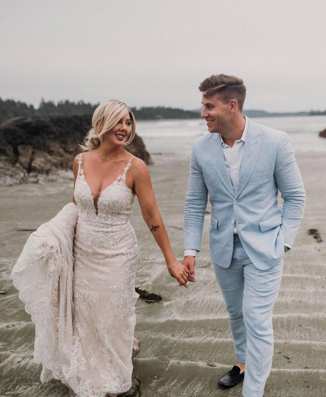 Couple walking outdoors, the groom in a pale-blue wedding suit, tailored in Edmonton